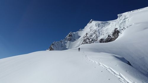 Scenic view of snowcapped mountains against clear blue sky