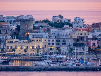 Sailboats in sea against buildings in city