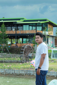 Side view of boy standing by building