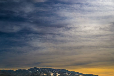 Scenic view of mountains against dramatic sky