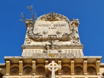 Low angle view of statue against blue sky