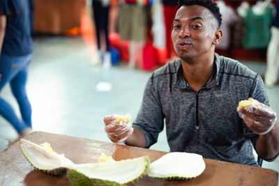 Midsection of man holding ice cream on table