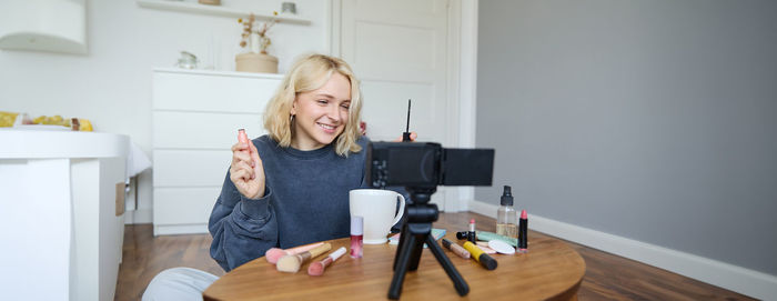 Portrait of young woman using digital tablet while sitting at home