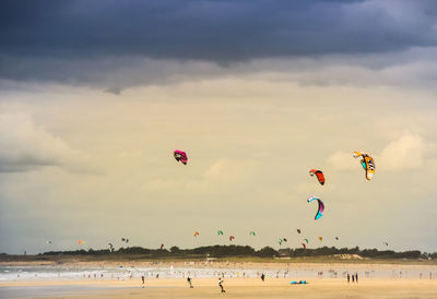 People with kiteboards at beach