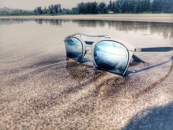 Sunglasses on lake against trees