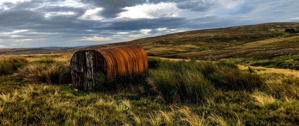 Hay bales on field against sky