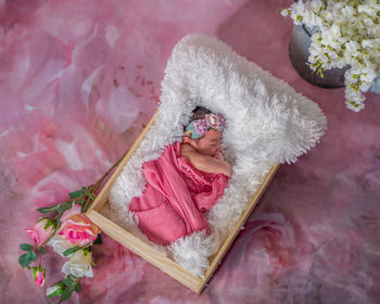 High angle view of baby girl in wood crate