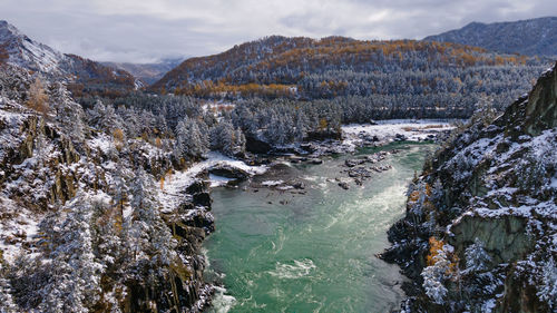 Scenic view of river against mountains during winter