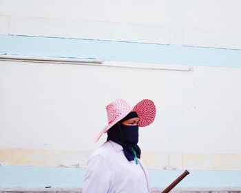 Rear view of woman standing against wall