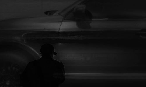 Rear view of silhouette man standing on shore
