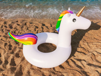 High angle view of inflatable ring on sand against sea at beach