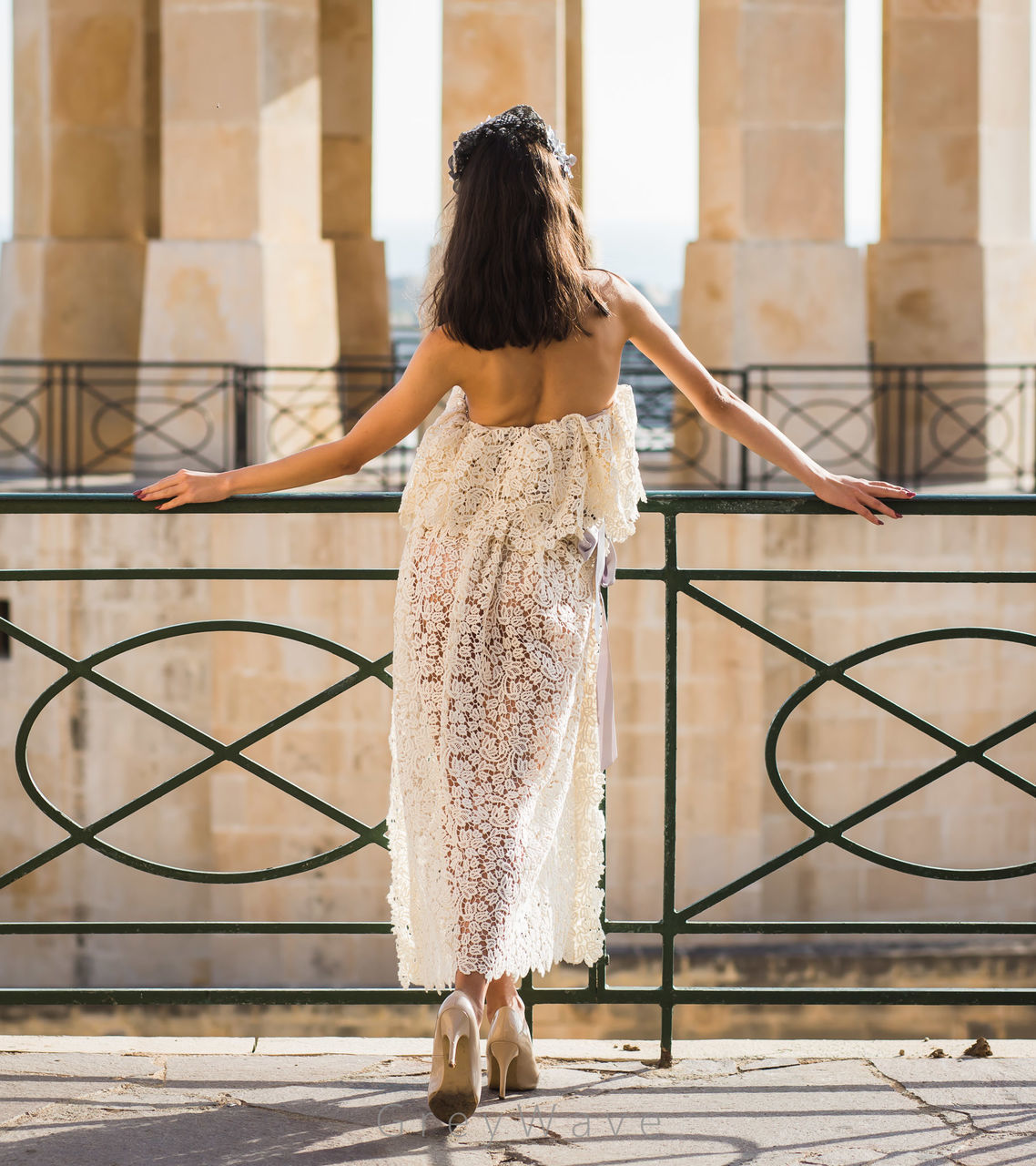 FULL LENGTH REAR VIEW OF WOMAN STANDING AGAINST RAILING