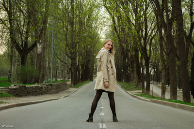 Full length of man standing on road in forest