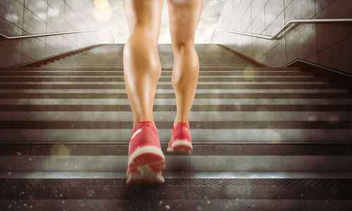 Low section of woman standing on staircase