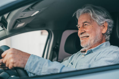 Smiling senior man sitting in car