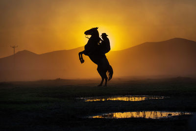 Silhouette man against orange sky during sunset