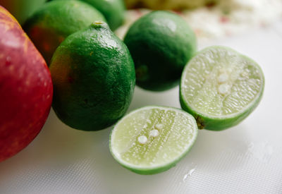 High angle view of lime and apple on cutting board