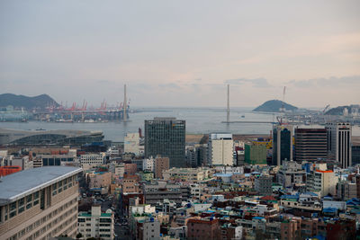 View of cityscape against cloudy sky