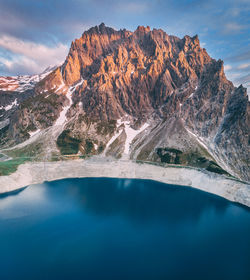 Scenic view of lake by mountain against sky