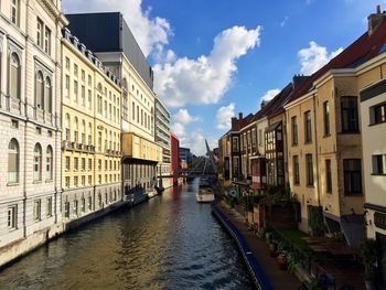 Canal amidst buildings in town against sky