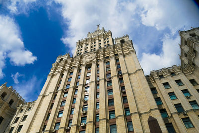 Low angle view of buildings against cloudy sky