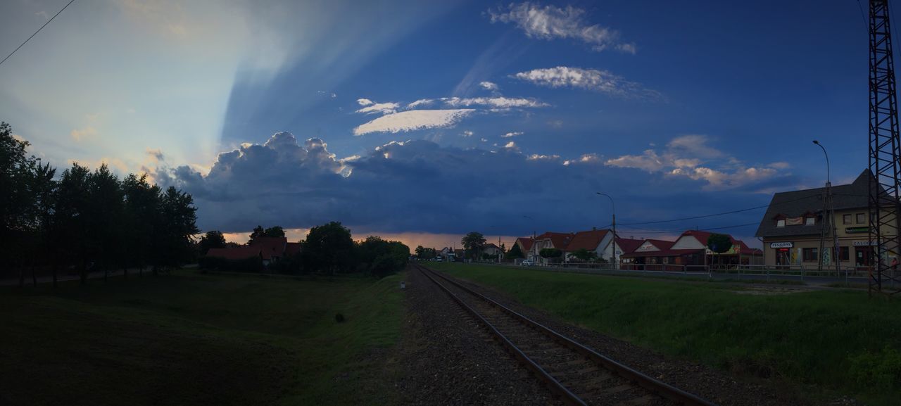 building exterior, sky, built structure, architecture, cloud - sky, landscape, the way forward, field, transportation, road, tree, rural scene, house, cloud, grass, sunlight, vanishing point, nature, diminishing perspective, railroad track