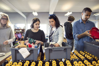 Volunteers looking in crate on production line