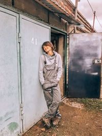 Full length of woman standing against building