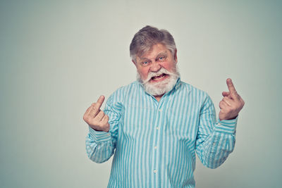 Portrait of man standing against gray background