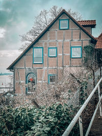 Exterior of house by building against sky