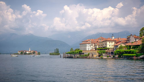 Buildings by sea against sky