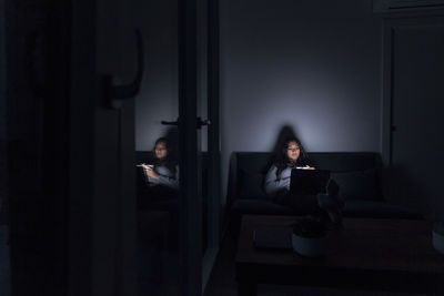 Young woman with laptop in room at home