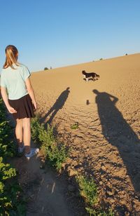 Rear view of woman on land against sky