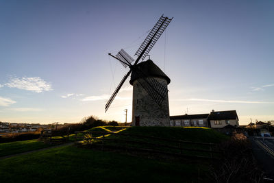 Traditional windmill on field against sky