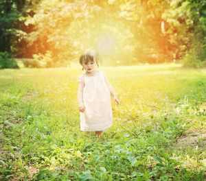 Girl walking on grassy meadow