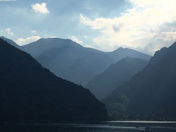 Scenic view of mountains by sea against sky