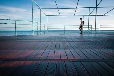 Full length of man standing by sea on pier