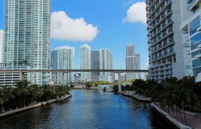 View of riverby buildings against sky