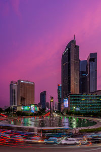 Modern buildings in city against sky during sunset