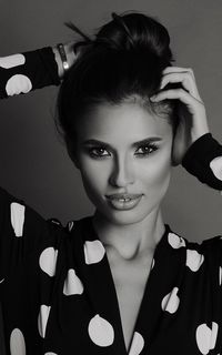 Close-up portrait of beautiful model standing against gray background