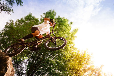 Low angle view of man riding bicycle against sky