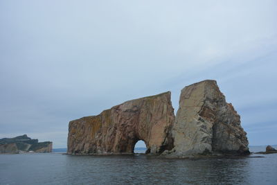 Rock formations by sea against sky