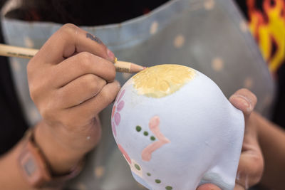 Midsection of woman painting egg
