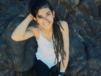 Portrait of smiling young woman on rock