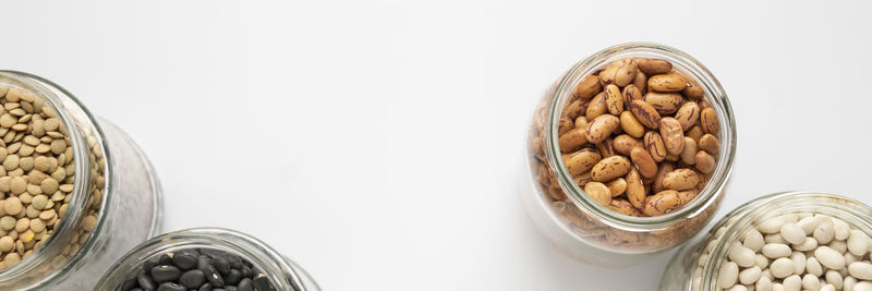 Close-up of glass jar on table against white background