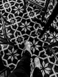 Low section of person standing on tiled floor