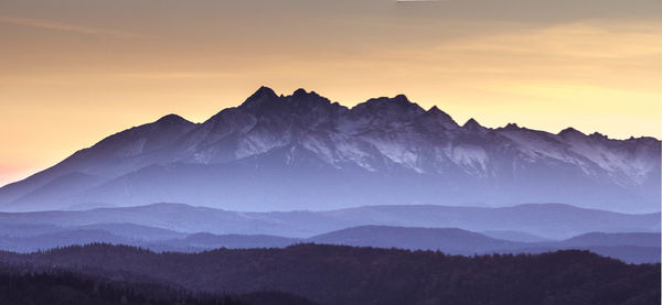 Scenic view of snowcapped mountains against sky during sunset