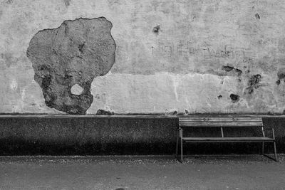 Empty bench against wall