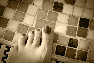 Low section of woman on tiled floor at home