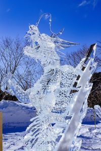 Snow covered tree against blue sky